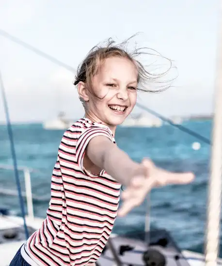 Kind auf Segelyacht im Wind – Yachtversicherung schützt Familie auf See
